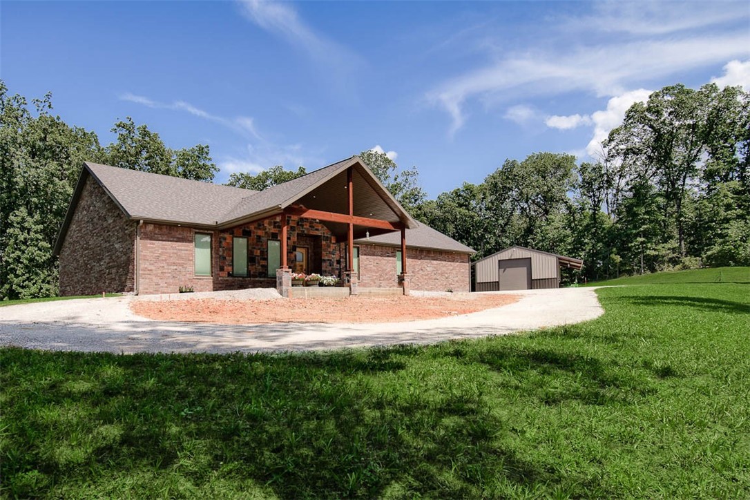 Gorgeous custom 2266 sq ft all brick home w/second 1218 sq ft barndo/metal shop home on 5 beautiful acres in the best location in NWA. Luxurious attention to every detail for quality, functionality & efficiency. Grand entrance w/custom oversized Alder wood door opens to breathtaking knotty pine ceilings throughout, abundant knotty alder cabinetry, magnificent main bedroom suite w/massive closets, dreamy spa like main bath w/heated flooring & towel warmers. Coveted laundry rm/storage. Massive and stunning granite countertops throughout including floor to ceiling backsplash. Black ice, top of the line Kitchen Aid appliances including fridge, W/D, gas cook top, ducted Venta Hood. Gorgeous, tiled flooring. H&A attic storage space. H&A pristine oversized 2 car garage/workshop space. Office space, safe room, glorious private back yard overlooking nature & dogwoods. Energy efficient in every way. The best Pella exterior doors & windows. Dual Heat system. Wonderful barndo has full kitchen, full bath, fridge, W/D.
