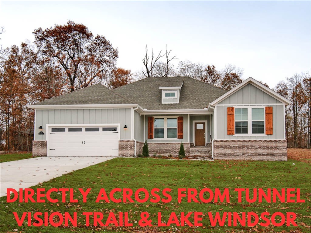 NEW CONSTRUCTION LOCATED DIRECTLY ACROSS THE STREET FROM THE TUNNEL VISION TRAIL & LAKE WINDSOR! LEVEL .32 ACRE LOT! Quick access to Bentonville. Features include a split floor plan, gas fireplace, LVP throughout, vaulted ceiling w/ beams, 3 cm counters, custom cabinets w/ wood hood, gas range, pantry, oversized eat-in kitchen, and high-end finishes throughout! Primary bath includes a large walk-in tile shower, free-standing soaking tub, double vanity, and generous closet space! Spacious covered patio area in both the front and back is ideal for entertaining! Approx completion date is 7/31/25 **Pictures may not be of exact unit listed, colors may vary slightly.