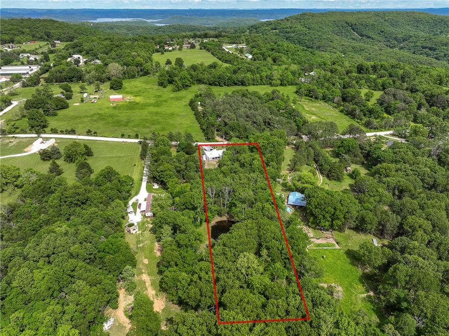 This one-of-a-kind home is tucked away in a peaceful, park-like setting near the lake—offering privacy, flexibility, and sustainable living. With its bright, open layout and large windows, the home feels connected to nature while still offering all the comforts of life. Relax or work from home on the private deck. Designed with eco-friendly living in mind, it has solar panels, a rainwater catchment system, and durable, low-maintenance metal siding. Perfect for those who love flexibility and an organic, eco-conscious lifestyle. The property includes a rental cabin and yurt, both with two full bathrooms nearby—great for family visits, guest stays, or extra income through short-term rentals. Multiple matching outbuildings, chicken coops, a storage shed, and an animal shelter make it easy to start a small homestead, hobby farm, or simply enjoy wide-open space. Minutes from the lake, I-49, and Rogers, this special property offers a unique mix of peace, practicality, and opportunity—ready for your next chapter.