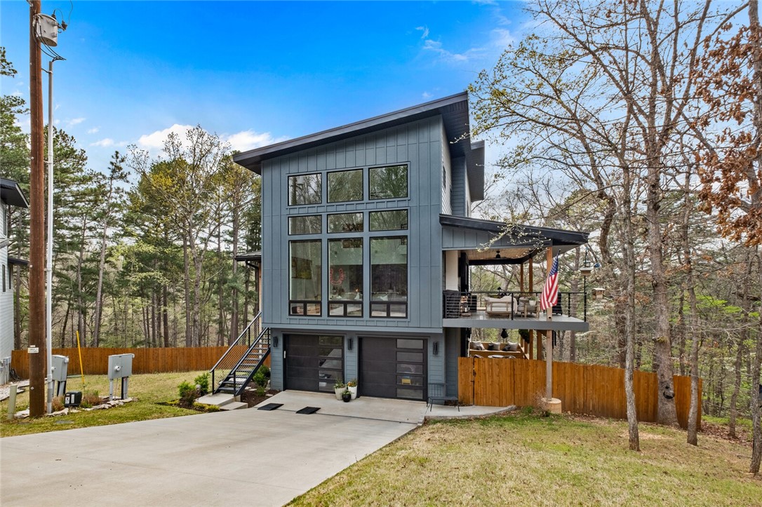 Where gorgeous modern comfort meets natural beauty. Professionally crafted in 2022 on over a half an acre sewered lot. This home features 3BR/3.5BA + office. Main level includes: floor to ceiling windows bringing in the natural light, eat in kitchen with Frigidaire Gallery appliances & quartz countertops. The main level has a bedroom, FB, utility, double sided FP in living room/back balcony. Sliding french doors off DR open to covered deck with composite decking that help you take in the tranquil setting of this home & extend the entertaining. Upstairs features: main bedroom with walk-in closet & en-suite bathroom featuring walk-in shower, water closet, and double vanity. Second guest bedroom is also upstairs with full bathroom access from hall. Basement features garage, storage lockers, built in desk & plenty of storage along with added office. Metal Cowboy pool conveys, near Back 40 Biking Trails, & wood/chain link fenced in yard. Come see the high end custom finishes mixed with beautiful designer touches.