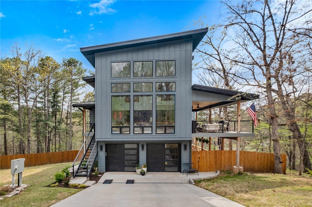 Where gorgeous modern comfort meets natural beauty. Professionally crafted in 2022 on over a half an acre sewered lot. This home features 3BR/3.5BA + office. Main level includes: floor to ceiling windows bringing in the natural light, eat in kitchen with Frigidaire Gallery appliances & quartz countertops. The main level has a bedroom, FB, utility, double sided FP in living room/back balcony. Sliding french doors off DR open to covered deck with composite decking that help you take in the tranquil setting of this home & extend the entertaining. Upstairs features: main bedroom with walk-in closet & en-suite bathroom featuring walk-in shower, water closet, and double vanity. Second guest bedroom is also upstairs with full bathroom access from hall. Basement features garage, storage lockers, built in desk & plenty of storage along with added office. Metal Cowboy pool conveys, near Back 40 Biking Trails, & wood/chain link fenced in yard. Come see the high end custom finishes mixed with beautiful designer touches.