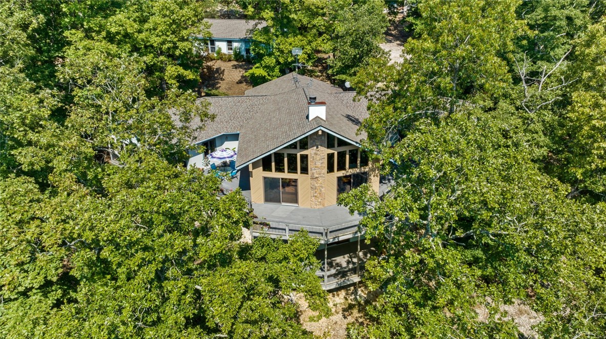 Fantastic lakefront home offering views, seclusion & 10x24 boat slip in community dock right out the door! Situated on 1.5 unrestricted acres & tucked away in a private cove off Little Coose Hollow, access to lake life is easy! Main level boasts split floorplan w/primary bed/bath/walk-in closets on one end & 2 guest beds/full bath on opposite end. Melding the two wings together is the heart of the home...a spacious great room w/wood-burning fireplace & wall of windows embracing the lake! The kitchen boasts an abundance of cabinetry w/full-extension drawers, rollouts, pantry & eat-in island. Completing the level is a ½ bath/laundry combo, office nook & dining room that could be a 2nd office, library, etc. Basement has ¾ bath & large family room beckoning multiple uses that walks out to another fabulous deck! A 26x38 shop & apartment w/kitchen, ¾ bath, bedroom awaits a revamp tailored to your needs (enlarged shop? in-law apt? guest house?). Come see this rural, peaceful home surrounded by dogwood trees & Beaver Lake!