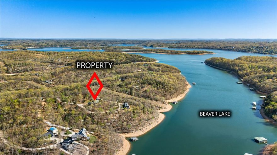 Nature abounds in this private oasis of over 7 acres! This is what lake living is all about!  There are 2 parcels with this listing!  One parcel is across Coose Hollow Lane (3.02 acres) Relax and enjoy life in this Beaver Lake Front home with a private 2 stall boat dock (with lifts) and swim platform!  Great Cove, fantastic lake location, private road off of Coose Hollow Lane. Endless opportunities with the flexible space this home offers! Large primary suite with a private deck and luxury bathroom. 
 Home features two full kitchens - could be an in-law suite or great for family get togethers. (two HVAC units with own meters).  
Huge loft, soaring vaulted ceilings, tons of character and charm, attic storage,
New roof in 2025! 
Two barns - one with a two-car garage, both are great for a shop and/or to park trailers, equipment, utility vehicles, etc. 

There is a path and cart path to the dock. Handicap accessible permit from Corps needed to use cart path all the way to dock.
Less than 20 minutes to Rogers!