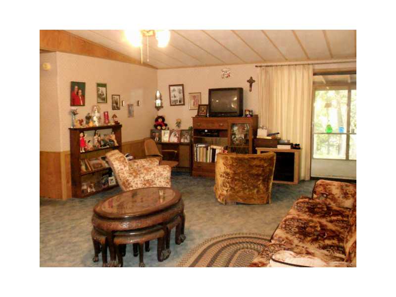 Excellent location on this .60 acre with nice 3/2 mobile on permanent foundation and large back covered porch. Oversized 2 car garage. Split plan with nice sized rooms that need updating. Minor cosmetic repairs needed but sold as-is. Overlooks veterans,park and Lake Bella Vista