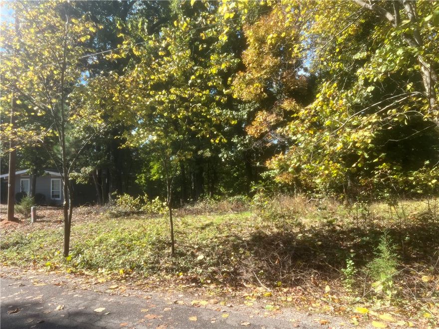 Discover the perfect blend of privacy and convenience on this beautiful wooded lot on Ulverston Dr in East Bella Vista. This gently sloped 0.30-acre cul-de-sac lot offers a mix of flat and wooded terrain, ideal for a custom home or investment build. Enjoy paved road access with utilities nearby, all in a quiet neighborhood just minutes from Lake Ann, Back 40 Trails, and Metfield Golf Course. Located in the Bentonville School District with quick access to 1-49, Harps, and local shopping. POA membership includes lakes, golf courses, and recreation centers. With new construction nearby and 36 acres of POA-owned land behind the property, you'll enjoy peaceful views year-round-snowy hillsides in winter, vibrant fall colors, and lush green summers, all without harsh morning sun. A prime opportunity to build in a scenic, thriving area.