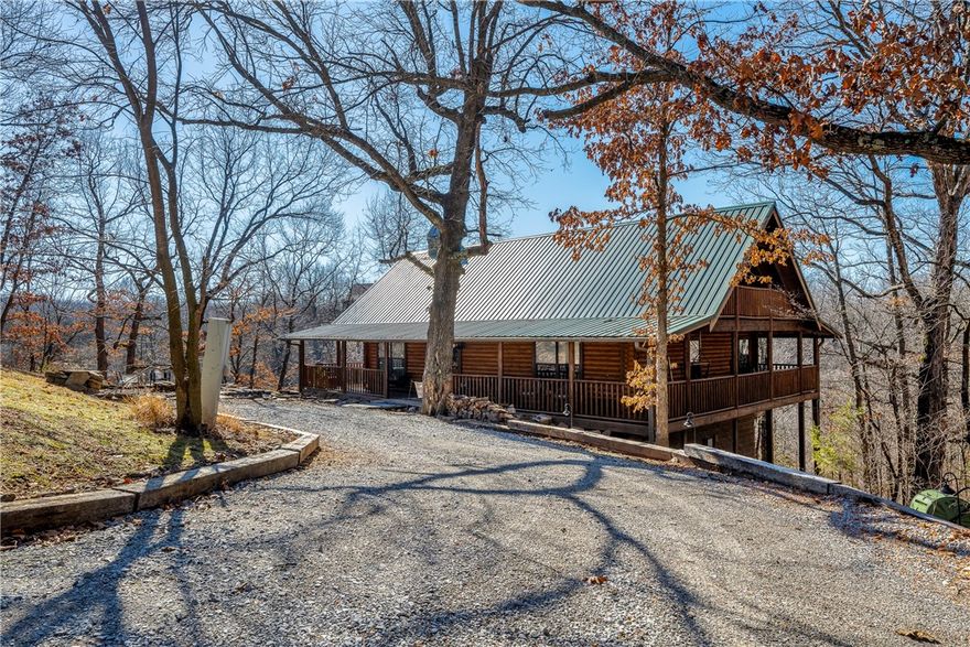 NWA Finest Log Home, gated community. The Cabins at Big Springs, located minutes from Gravette, easy access to I-49, less than 30 minutes from Bentonville, Rogers, and Missouri! True log cabin for rural living at its finest! 2022 totally renovated & fully furnished modern cabin w/ metal roof to save tons on insurance! 2nd home or investment w/nightly rental options. Access to 180 acres of common area, spring fed lake, family pavilion, kids zone, biking trails, & much more. Built in 2006, home features; stunning rock, wood burning fireplace & open, yet cozy living room/dining space/kitchen. Two bedrooms, two full baths, & real wood floors/walls/& ceilings to embody that real log cabin aesthetic. Outside, soak up nature from your wrap-around porch, sit on the deck overlooking the stocked lake & beautiful view, enjoy fire pit for entertaining within the mature setting. POA maintains yards, minimal maintenance. Appointment is required.