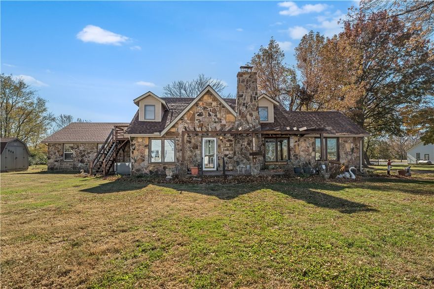 Spacious homestead on nearly 2 acres in the heart of Hiwasse! This property offers a rare mix of usable land, mature trees, and multiple outbuildings—including a large detached shop/barn, covered carport, and storage structures. The home features hardwood floors, abundant natural light, and a striking floor-to-ceiling stone fireplace. Just steps from Hiwasse Park and minutes to the I-49/HWY 72 interchange, this location blends convenience with a peaceful country feel. Tons of potential for a homestead, hobbyist, or future improvements. Appraisal available upon request.