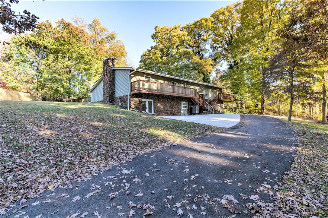Amazing location! Just .8 mile Bentonville Square; 1/2 block from trail access and Park Springs Park. Incredible family home; location makes it a sought-after investment potential. House sits back from road on .62 acre; overlooks large yard; mature wonderful trees. Large deck. Interior remodeled; beautiful/comfortable. No carpet. Several rooms real hardwood floors. Both bathrooms main level have jetted tubs & walk-in tile showers. Basement has newer walk-in tile shower. Master his/her closets. Kitchen has copper farmhouse sink, roll-out drawers, granite, 2 ovens, gas range, pot-filler, warming drawer, stainless appliances. In addition to spacious livingroom, the main level has a large room with lots of windows facing back yard. Full finished walkout basement has very large space for family room, bonus room, media room; basement also has kitchen, full bath, bedroom, 2nd laundry (laundry also main level). Two stone fireplaces; main level wood-burning or gas log; basement has insert w/thermostat.