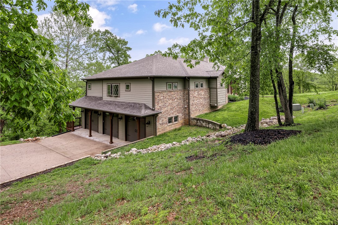 Escape to serene lake living in this breathtaking home nestled on over 2 acres of native hardwoods. This home offers an exceptional blend of luxury & nature. Main level ft. a spacious living rm that provides natural sunlight pouring thru a wall of windows, the inviting stone-accented wood burning FP is a stunning focal point. Kitchen is equipped top-of-the-line Bluestar gas cooktop & double wall ovens w/warming drawer. The pot filler & spacious island provide easy meal prep & entertaining, complemented by an open dining area & walk around pantry. Primary suite that conveniently flows into a functional laundry rm, powder bath, 2 secondary bdrms, a full bath & dedicated office space are also featured on main level. Descend to the lower level where polished stained concrete floors lead to a 2nd living area, full bar, 4th bedroom, full bath & versatile flex room w/secure safe room for peace of mind. Tons of upgrades throughout! 2 tranquil outdoor spaces that beckon you to unwind & savor the peaceful nature around you