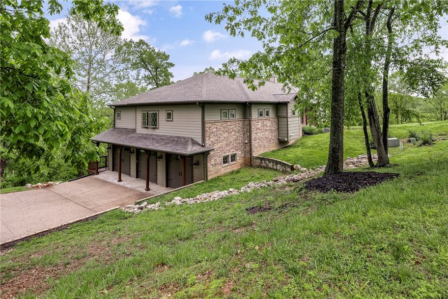 Escape to serene lake living in this breathtaking home nestled on over 2 acres of native hardwoods. This home offers an exceptional blend of luxury & nature. Main level ft. a spacious living rm that provides natural sunlight pouring thru a wall of windows, the inviting stone-accented wood burning FP is a stunning focal point. Kitchen is equipped top-of-the-line Bluestar gas cooktop & double wall ovens w/warming drawer. The pot filler & spacious island provide easy meal prep & entertaining, complemented by an open dining area & walk around pantry. Primary suite that conveniently flows into a functional laundry rm, powder bath, 2 secondary bdrms, a full bath & dedicated office space are also featured on main level. Descend to the lower level where polished stained concrete floors lead to a 2nd living area, full bar, 4th bedroom, full bath & versatile flex room w/secure safe room for peace of mind. Tons of upgrades throughout! 2 tranquil outdoor spaces that beckon you to unwind & savor the peaceful nature around you