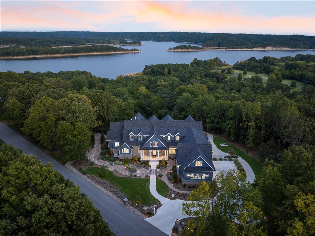 Prepare to be awestruck by this extraordinary 5-bed, 6.5-bath, 8,321 sqft masterpiece, nestled on 6 acres in Rogers that includes ownership of TWO slips in a co-owned boat dock, enhancing your access to the pristine Beaver Lake. Perched atop a hill, it offers unparalleled, jaw-dropping views of Beaver Lake that will leave you spellbound. This architectural gem showcases a well-thought-out floor plan & layout that exudes sophistication at every turn. Indulge in the lap of luxury with a sparkling pool & a poolside pergola, ideal for savoring leisurely afternoons & entertaining under the sun. Perfectly situated a mere 10-minute drive from Downtown Rogers. If you're seeking the epitome of luxury living, where every detail has been meticulously crafted to provide comfort, beauty, and tranquility, this is the property you've been dreaming of. Don't miss this rare opportunity to own a slice of paradise with unmatched Beaver Lake views. Your dream home awaits! *All furnishings negotiable with acceptable offer.*