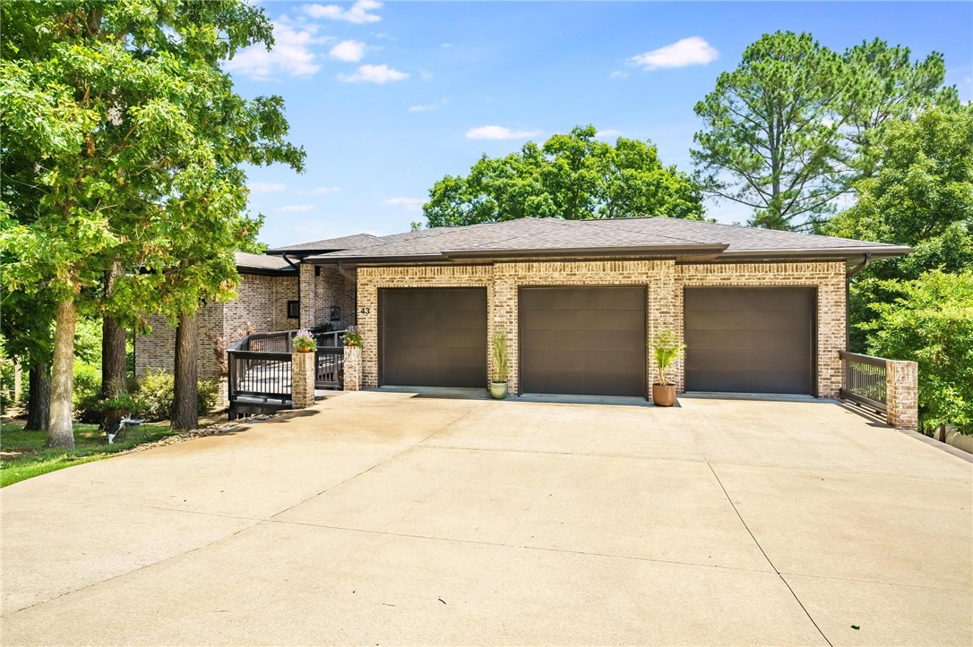 Contemporary 3 bed, 2 full & 2 half bath home on the 16th hole at Scotsdale Golf Club! Built in 2015, this 3185 SF home includes an additional 1012 SF heated/cooled space with a 595 SF workshop. Main-floor primary suite offers a luxury bath with double vanity, air jet tub, walk-in shower & his/her closets. Chef’s kitchen boasts a large island, Sub-Zero fridge & propane cooktop. Enjoy two Trex decks, a firepit, and stunning views. With 2x6 construction, and full brick...this is a rare find in beautiful Bella Vista! Two more Bedrooms and Guest bath in the lower level. There's even a storm shelter to keep you safe. This beauty won't last long...Welcome Home!