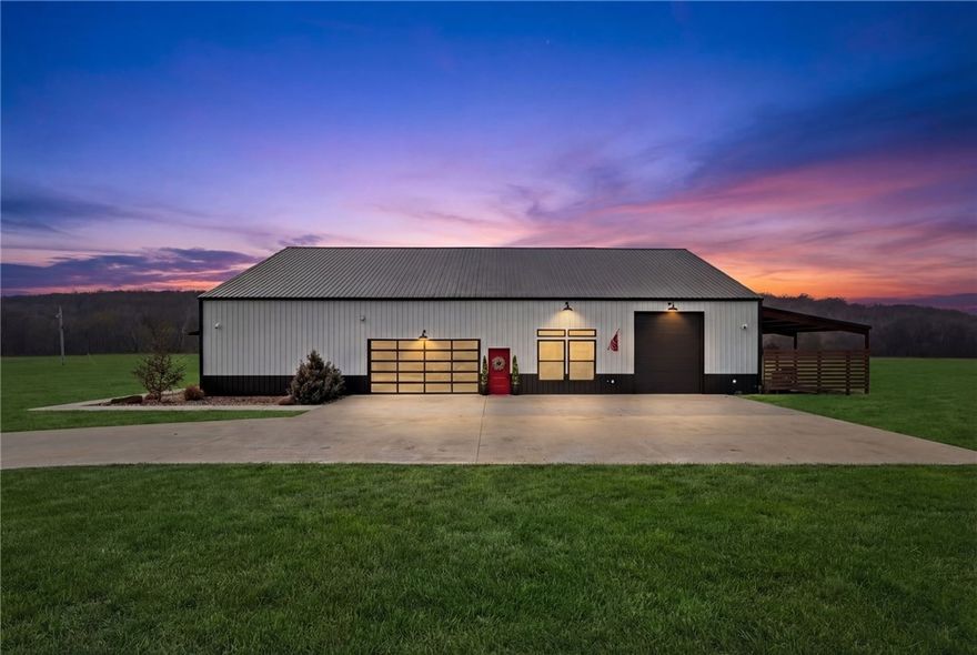 Modern farmhouse estate on 10 private acres in Prairie Grove with direct frontage along Sulphur Fork Creek. This 4-bedroom, 3-bath residence features 10-foot ceilings throughout, hardwood flooring, black-framed windows, red iron building construction and a seamless open layout designed for both entertaining and everyday living. The chef’s kitchen offers custom cabinetry, double ovens, an oversized island, and an expansive walk-in pantry. Dedicated office and bonus room provide flexibility. Outdoors includes a private pond, covered patio, and a 1,000 sq ft shop with 12-ft pull-through doors on both sides. A rare blend of refined design and functional acreage.