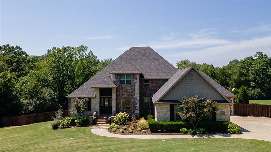 Executive home in E. Fayetteville, designed for entertaining! Two primary suites on the main level, a large media room with a wet bar, GE generator, an outdoor covered kitchen space with flagstone patio, a newly built firepit, a new hot tub, en suite baths in all bedrooms. Hug closets, dual sinks, 12' ceilings plus, grand home office, large laundry room, and open floor plan. Feels like country living, but only 5 minutes to Mission/Crossover. This is a must-see! Sellers are offering a flooring allowance for hardwood floors of $15,000, to be paid at closing.
