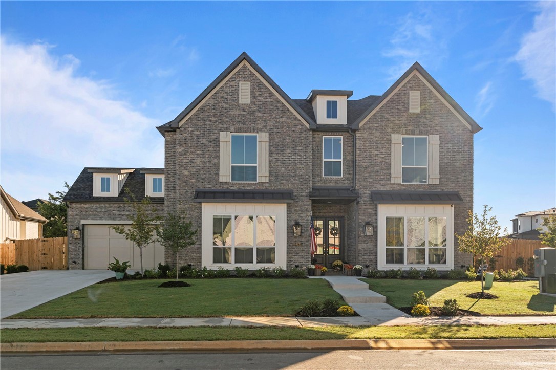 A 2025 Buffington Homes, Hamilton plan! Ask about our preferred lender incentives! A stunning 4-bed, 5-bath + OFFICE + BONUS in Bentonville school district! Enter through beautiful double doors into a spacious, open-concept layout with soaring 12-ft ceilings & abundant natural light. The living room boasts a striking indoor gas fireplace with a single exposed beam mantle & stone detailing. The chef-inspired kitchen features 3 cm quartz countertops, custom cabinets to the ceiling, & luxurious GE Cafe appliances, while an extended white oak island provides extra storage & prep space. Relax in the luxurious Primary Retreat, complete with a soaking tub, large shower, & spacious walk-in closet. Upstairs, find a game room & three bedrooms, two full baths, & custom tile upgrades in all bathrooms. Enjoy outdoor living on the vaulted-ceiling patio with an outdoor gas fireplace. The garage is insulated, has an epoxy floor, & includes a 240V outlet. This home is perfect for entertaining, relaxing, & everyday living!