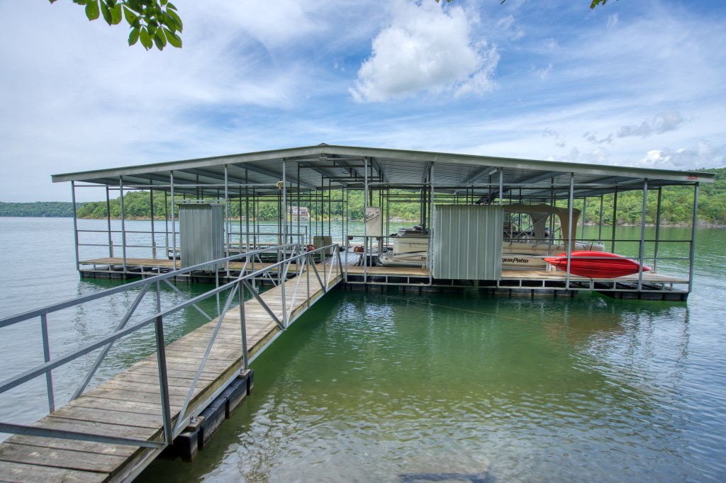 This amazing Beaver Lake front lot includes a slip in a four slip community dock located right in front of the lot! Multiple building locations allow you to choose how you want to use the property. Building on the flat lake front level will give you easy and quick access to the dock. The top of the lot gives you the ability to clear the trees and have an great lake view. A third building location above the cliff line could give you a compromise between the two! This land is accessed by paved roads in a well-established subdivision of nice homes. Dock slips are scarce and now is the time to buy for your future!