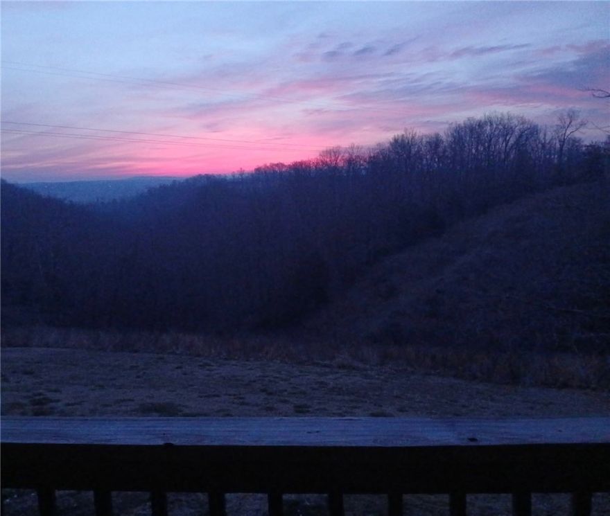 Perched atop a picturesque ridge minutes from Huntsville and only ~30 minutes to Springdale/Fayetteville, this home offers a rare blend of privacy, space, and scenic elevation—without remote isolation. The main floor’s light-filled living areas are ideal for relaxed evenings or entertaining, and the expansive deck captures sweeping valley views. Downstairs, the finished walk-out basement is now a home gym but easily converts to a media room, playroom, guest suite, or in-law space. Built in 2008 with a new roof and HVAC in 2023, this home combines quality with ease of ownership. On just over five acres, the natural terrain offers low-maintenance living and a true hillside sanctuary—no flat-lot upkeep, just your private retreat. Whether sipping morning coffee on the deck, entertaining under the stars, or enjoying the open lower level, this home is built for meaningful living and memorable moments. Recently appraised near $600,000, it offers instant equity and an exceptional location. View the 3D Matterport tour!