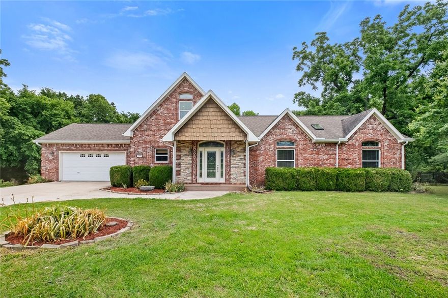 Location, location, location! Five miles to I-49 and less than 10 mins to Lake Wedington. This home is beautifully surrounded by mature trees on a 1 acre lot, and boasts an open floor plan with an A-frame wall of windows to allow natural light throughout the home. Chef's kitchen with custom white cabinets, some with glass fronts for display, also includes a butcher block island. Family room with vaulted ceilings, fireplace flanked with built-ins. Great sized owners suite with barrel vault ceiling, with accent lighting. Primary Spa-like bath with detailed custom tile work, and double walk-in shower. Secondary bedrooms with oversized closet space. Upstairs bonus room would make a great office, play room, or den overlooking the living area. You will enjoy entertaining on the spacious back deck, and gathering the family around the bonfire area to enjoy the privacy that awaits you.