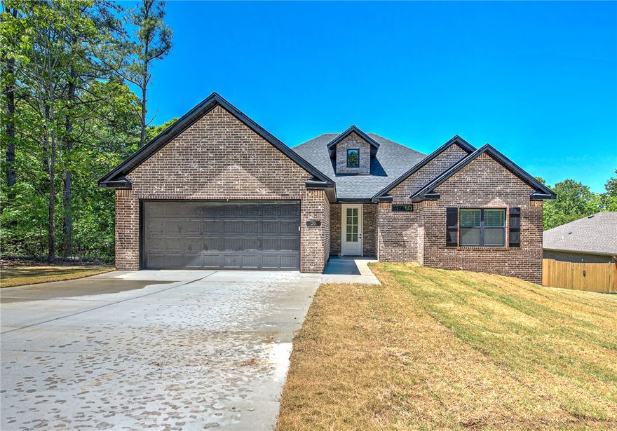 Beautiful new construction 3BR/2BA home in Bella Vista featuring modern finishes, an open-concept layout, and a peaceful wooded setting. The spacious living room offers vaulted ceilings with exposed beams, abundant natural light, and a stunning brick fireplace that creates a warm focal point. The kitchen is designed for entertaining with quartz countertops, custom cabinetry, stainless steel appliances, large center island, and stylish backsplash details. The private primary suite includes a spa-inspired bath with double vanities, soaking tub, walk-in shower, and generous walk-in closet. Durable wood-look flooring flows through the main living areas with comfortable carpet in the bedrooms. Step outside to enjoy the covered back deck overlooking the large backyard and surrounding trees. Conveniently located near Bella Vista’s golf courses, lakes, Bike trails, and amenities with easy access to Bentonville. This is a 2 Bedroom home Septic System
