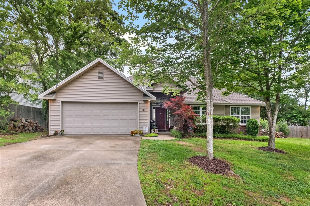 One-level Bella Vista home with an additional buildable lot- totals 0.68 acres! This lovely home offers plenty of room for playing, gardening, exploring the woods or building another house next door. An 18' gate leads into a large, primarily flat, cleared backyard flanked by wooded terrain. When you walk into the spacious living room, you are greeted by soaring 12' ceilings and ample windows offering plenty of light. The back deck is the perfect spot for enjoying the outdoors. The cozy kitchen has a wood-burning stove, perfect for cool winter nights. Recent updates include new carpet in the bedrooms, a new roof (2018), a new water heater (2021), and a newer HVAC (approx 5 years ago). The washer, dryer, refrigerator, Ring doorbell, and security system convey. Bella Vista offers many amenities, including lakes, parks, walking trails, mountain biking trails, golf courses, clubhouses, basketball, and tennis courts. Convenient to highway 71 and nearby grocery shopping.
