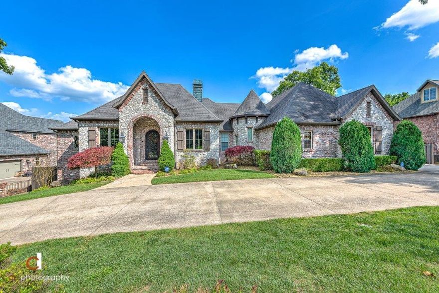 A STUNNING EUROPEAN STYLE CUSTOM-BUILT ESTATE SHOWCASING BEAUTIFUL CRAFTSMANSHIP THROUGHOUT, LOTS OF UPDATES AND A BACKYARD PARADISE COMPLETE WITH INFINITY EDGE GUNITE POOL, HOT TUB, CUSTOM PLAYGROUND, A COVERED DECK AND PATIO ALL OVERLOOKING A PRIVATE TREED VIEW!  This entertainer’s dream is tucked away on a .81 acre setting and features a private study, formal dining, fabulous gourmet kitchen and 2nd kitchen on basement level, 3 living areas, fully equipped media room, main level master retreat and main level guest suite, amazing storage space, and 2 laundry rooms!  Beautiful hand scraped wood flooring, custom wall treatments, plantation shutters, vaulted beamed ceilings, custom built-ins, professional grade appliances, exquisite spiral staircase and so much more! 4 car side load garage, front circle drive.  Just 3 miles from Downtown Bentonville with easy access to I-49!
