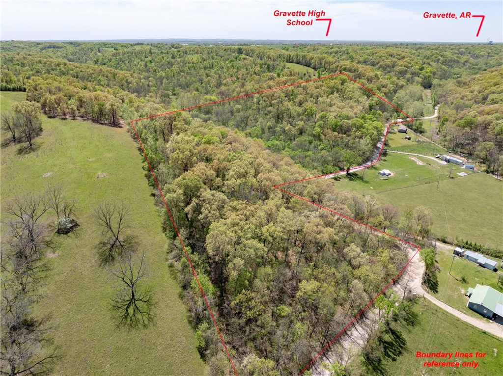 Endless possibilities on this scenic tract just over a mile from downtown Gravette and a short drive to Bentonville. This private, forested retreat offers natural beauty, seclusion, and potential for residential or recreational use. Rolling terrain, seasonal creeks, and views of the Ozark foothills make it ideal for those seeking a peaceful homesite, second home, or a unique getaway. Enjoy space to explore—perfect for hiking, ATV trails, mountain biking, or developing a private retreat. Multiple potential building sites allow for flexibility, whether you're envisioning one estate home, a few secluded cabins, or a weekend escape for everyone. A rare opportunity to own land that offers both privacy and proximity to Northwest Arkansas amenities.