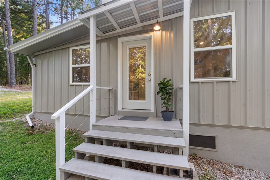 Tucked away in the scenic Ozarks just minutes from historic Eureka Springs, this 2 bed, 1 bath contemporary cottage offers the perfect mix of comfort, privacy, and off-grid living on 7.5 unrestricted acres. Fully furnished and move-in ready, this 960 sq ft home features modern updates, underground electric, backup solar, propane, and a 3000-gallon water storage system with whole-house PEX plumbing—no well needed. Enjoy wooded privacy, abundant wildlife, and plenty of space to relax or expand. A dedicated RV site with electric hookup and dump station adds options for guests, rental, or travel. Additional features include multiple building sites, an insulated storage shed, and a garden area. With no restrictions, this property offers freedom to build, expand, or simply enjoy the peace and quiet. Located just off Hwy 187, you're close to all the attractions of Eureka Springs, yet tucked away enough to enjoy true Ozark seclusion. Conventional Loans May not support without a well; please contact agent for questions.