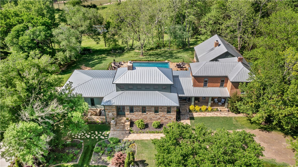 This estate spans almost 90 acres of gorgeous farmland, including a registered USDA conservation pine forest with hundreds of feet of White River frontage. Dating back to pre-Civil War, the historic brick main house has been restored & renovated with attention paid to preserving historic provenance. A seamlessly designed addition was added in 2019, featuring a large open great room & impressive kitchen opened to the screened in porch with folding wall of doors. Grandeur abounds in the 6,002 sq ft residence with imported terra cotta tile from French stables, original pine flooring, imported silk & grass cloth wallcoverings, antique wood beams, original fireplaces & one-of-a-kind custom chandeliers. The property is meticulously maintained with a newly added gunite pool & expansive porches. Additionally on the property is a 2,556 sq ft party barn/guest house built for office & living space with 3 bedrooms & 1.5 bathrooms, kitchen, living room & custom outdoor stone patio & fireplace. Enjoy the 2,491 sq ft shop/garage.