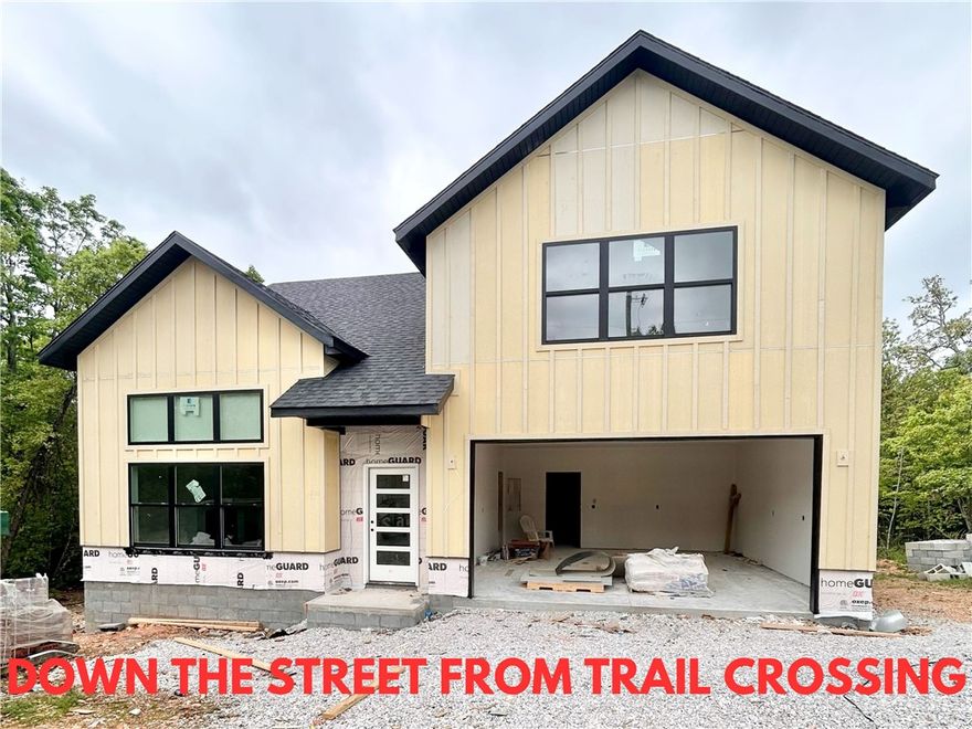 New construction home on a large .31-acre wooded lot! Just down the street from the Taylor Homestead Trail Crossing! Step into a bright and airy interior featuring tall ceilings and a striking 2-story fireplace. The kitchen boasts custom cabinets, a gas range, and 3 cm quartz countertops. The primary bath features a luxurious soaking tub and a walk-in tile shower. Enjoy abundant natural light throughout, and entertain on the spacious deck overlooking the serene landscape. Custom finishes throughout. Bentonville schools! As an added bonus, receive $3,500 towards buyer's closing costs when working with the builder’s preferred local lender! Schedule your showing today!