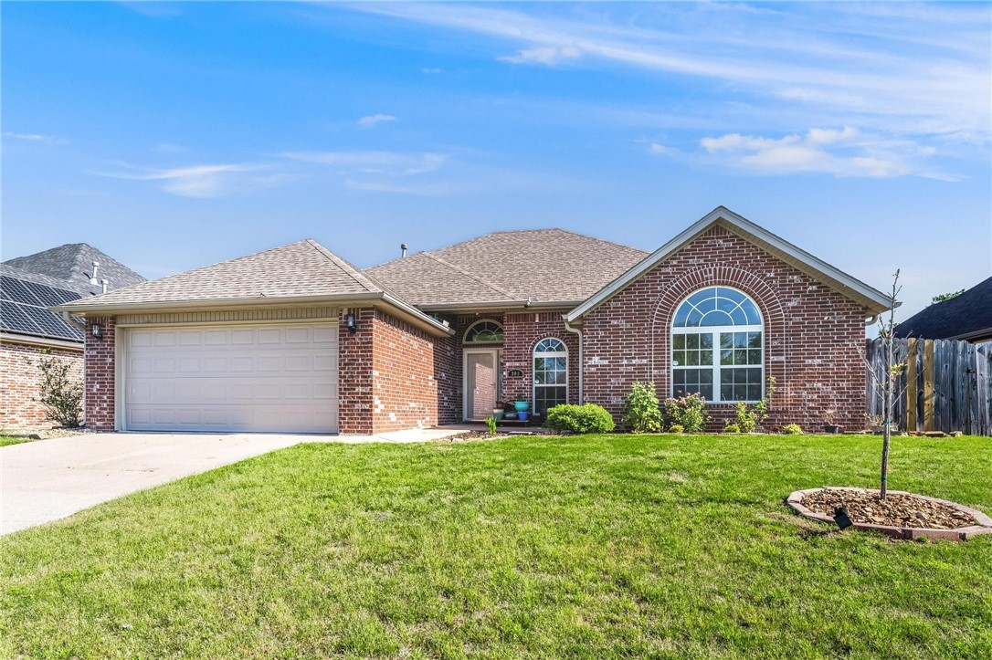 This home offers the perfect blend of convenience, comfort, and outdoor living. Ideally located just 10 minutes from Downtown Rogers, 15 minutes from Prairie Creek Marina, and only 5 miles from Highway 149. Freshly painted with new flooring in all three generously sized bedrooms, this move-in ready home welcomes you with a spacious living room anchored by a cozy gas-burning fireplace. The kitchen is well-appointed with a gas stove/double ovens, refrigerator, vented microwave hood, and ample counter space. A utility room offers extra storage and includes a washer and dryer. The split floor plan provides privacy with the master suite located on one side of the home. The master retreat features a tray ceiling and bathroom complete with a walk-in shower, dual vanities, tub, and two generous closets.
Step outside to enjoy the screened-in patio overlooking a landscaped, fenced, and flat backyard—ideal for pets, play, or gardening. New Roof September 2024.