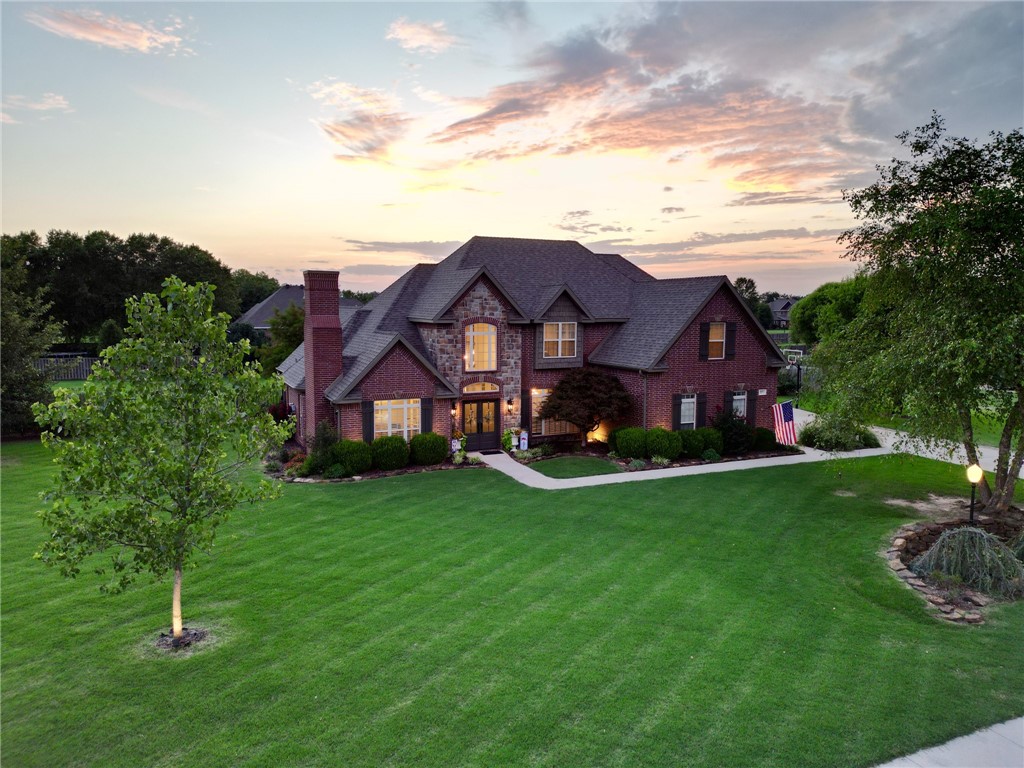 Welcome to this stunning all-brick 4 bed, 3.5 bath home nestled on a 1-acre lot in a peaceful & picturesque neighborhood. Conveniently located near the newly developed Shaw Family Park & I-49 w/easy access to Elm Springs Rd amenities. As you step inside, you'll see the grand entryway opening up to the den/office area w/gas fireplace, formal dining area, & spacious living area w/ 20-foot ceilings, a wood-burning fireplace, wet-bar, & French doors leading to the back patio. The large kitchen has all stainless-steel appliances w/gas cooktop, eat-in dining, plenty of cabinets, & a sitting area w/door leading outback. Primary bedroom features cathedral ceilings & an ensuite w/separate vanities, walk-in shower, whirlpool jetted tub, & large walk-in closet. Upstairs, you'll find a second primary bedroom w/ ensuite as well as 2 additional bedrooms w/a jack-&-jill bathroom. Firepit outback to enjoy. 3-car garage & basketball goal. New roof & LVP downstairs 2021. New carpet upstairs 2023. Fresh exterior/interior paint 2022.