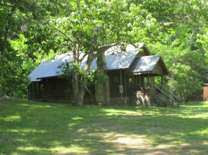 This is a Creek Farm on Calf Creek. Lots of good bottom land and two nice lake ponds. The log cabin has been restored beautifly and is in a rental program for $ 100.00 per night. Immediately behind the cabin is a Cave at the base of a Bluff in the back yard of the Cabin.