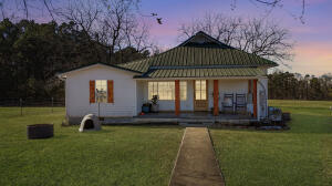 Step into timeless elegance with this beautifully updated 3-bedroom, 1-bath farmhouse nestled on approximately 3 acres of serene countryside. Perfectly blending classic charm and modern conveniences, this home is a true retreat!Relax on the covered front porch, perfect for enjoying quiet mornings or winding down in the evening. The property also features a brand-new 10 x 16 Trex deck, ideal for entertaining or soaking in the natural surroundings.The detached 2-car carport includes a 10 x 22 storage room/workshop, providing ample space for hobbies, projects, or extra storage. The fenced-in yard offers privacy and a safe haven for pets or children. With both public water and two wells (one with a submersible pump and the other with a traditional pitcher pump), you'll have