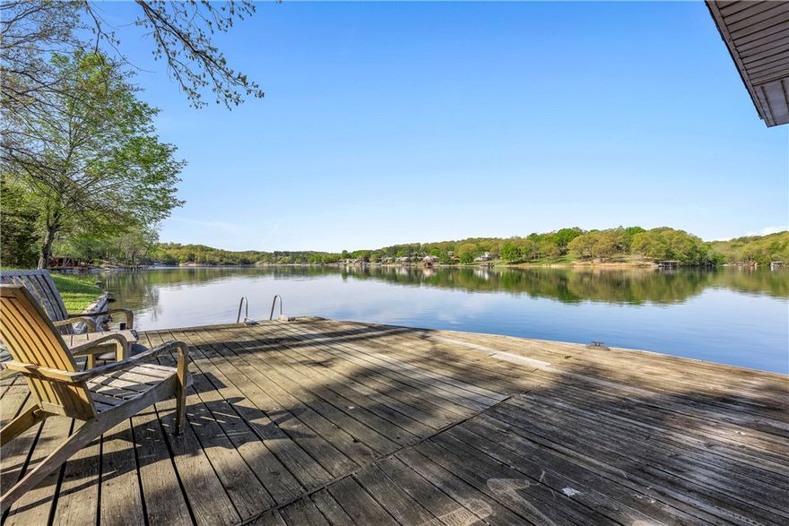 Want to live the lake life?  This home has beautiful views of Lake Windsor from almost every room.  Real wood floors, open living area.  Updated bathrooms.  Home has upper and lower decks.  Covered private dock.  Convenient location.  Easy access to Hwy 49.  Close to grocery stores and club house.  Golf, tennis and rec center are just minutes away.  Bike trail located in the neighborhood. Bentonville School District. The home is sold "As is" so the buyer can make any updates to their liking or live in it just the way it is.  Either way,  you will love living on Lake Windsor.