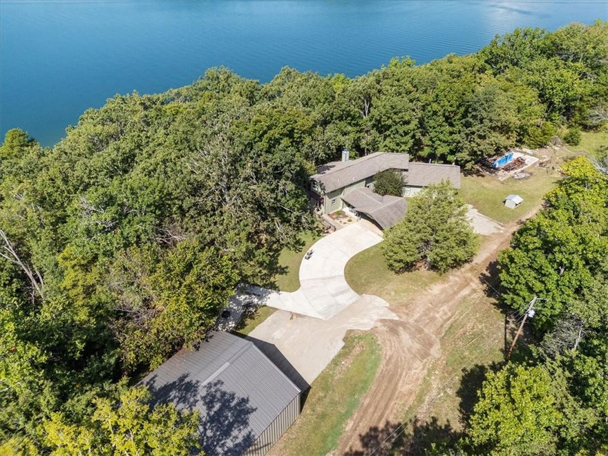 LAKEFRONT with a 10'x26' slip in a Community dock. his magnificent, and very private, home & shop have been meticulously maintained. Completely remodeled and an additional 1000 sq ft was added in 2017-attentiom to details everywhere!!
The bar in the kitchen and stairs & handrail leading to 2nd level are all custom handcrafted. There is a fabulous customized forced-air wood-burning fireplace in the living room for those chilly nights enjoying lake views from indoors. Anderson, tilt-in windows throughout, all LG appliances in the kitchen and soft-close cabinets/drawers throughout the house. The Primary Bathroom boasts an inviting jetted tub and a separate heat/air unit for "zoned" temperature comfort.  1600 sq ft shop with 100 amp power-all run in conduit- on a 6" monolithic-design slab, 3" conduit in each corner of slab for future water/electric needs, a ducted woodstove and propane heat available in this fully insulated shop! Lot 1 in Beavers Cove subdivision conveys with this property (see add'l parcel # listed)