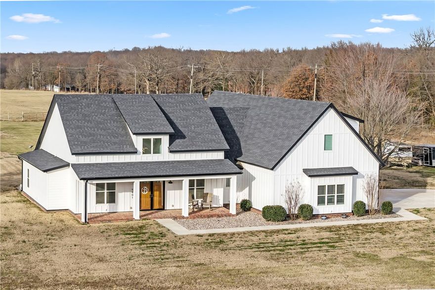 Discover the perfect blend of country living and modern convenience. Motivated Sellers are offering this stunning 2021-built modern farmhouse which sits on a generous 3.7-ac lot, offering the space and privacy you've been dreaming of while keeping you in Bentonville School District. With 3,290 sqft of thoughtfully designed living space, this home features soaring cathedral ceilings, a split floor plan, and luxurious finishes including wood flooring and custom built-ins. The heart of the home showcases a gourmet kitchen with propane cooktop, while the bonus room upstairs provides endless possibilities. Step outside to your private retreat featuring a covered patio overlooking your in-ground pool—perfect for entertaining or unwinding. The 3-car attached garage and level, cleared lot provide plenty of room for toys or hobbies. Don't miss this rare opportunity to own a nearly-new modern farmhouse with resort-style amenities.