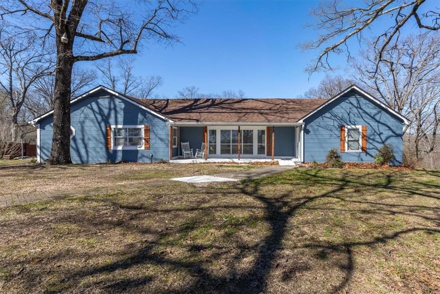 Priced below appraised value with immediate opportunity for value. Move-in ready with real hardwood floors, updated light fixtures, roof replaced in 2023, and brand-new HVAC. Renovated kitchen features soft-close cabinets, quartz countertops, new appliances, and coffee bar/prep area with secondary sink. Flexible layout offers two en-suites, main living plus second living room/sunroom, formal dining, three full baths, and oversized laundry/mudroom with sink. Covered front porch and great back deck. Situated on 2.16 acres between Rogers and Eureka Springs near lake areas. May suit primary, second home, or short-term rental use.