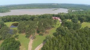 SECLUDED COUNTRY HAVEN on the water! Phenomenal, log-sided retreat offers a quiet world of wildlife & peaceful solitude with AR River access. First time on market, this 2007 home offers magnificent beamed, cathedral ceilings, fireplace, walk-out basement, shaded back deck and wrap-around porches. Making this home special are master suites & garages on each floor offering ground-level access. Potential for 2+ more bedrooms if preferred over the 30x30 heated basement shop garage. Enjoy hunting or relaxation from the shaded back deck and wrap-around porches, or fish for supper from the ponds filled with crappie and bass. A ''Free Gas'' Lease conveys along with all gas appliances. Property boasts a gated entrance, 24+ acres, 3 ponds, small shop, and RV hookup. Additional 38 acres available.