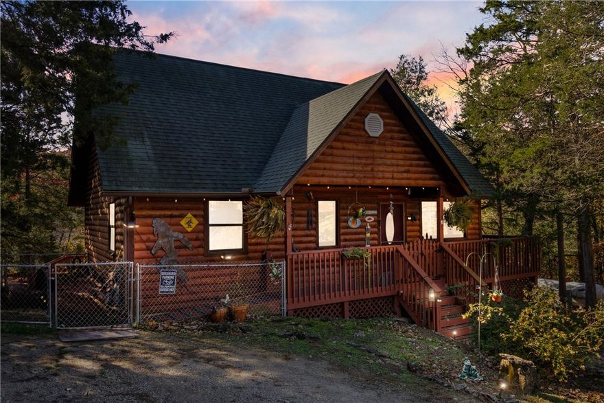 Nestled on a quiet street in Holiday Island, this charming log-sided home offers peaceful living with beautiful mountain views from the back deck. Inside, massive windows flood the open living room with natural light, highlighting the soaring vaulted ceilings, V-groove accents, and warm wood details throughout. The galley kitchen features a propane range and easy flow into the spacious laundry room with ample room for pantry shelving. A large, open loft upstairs serves perfectly as a third bedroom or flexible living space. The bathrooms are thoughtfully finished, including one fully remodeled in 2024. Major updates include a new HVAC system with app-controlled thermostat installed in September 2025 and a new hot water tank in 2024. Enjoy quiet mornings and wildlife watching from the wraparound porch, or make use of the fenced side yard ideal for pets. Tranquil, bright, and full of character — this home captures the best of Ozark living.