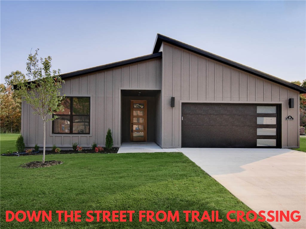 Modern new construction home just down the street from the Taylor Homestead trail crossing! Flat .30 acre wooded lot! This stunning residence features a waterfall kitchen island, stainless steel appliances, gas range, 3 cm quartz countertops, walk-in pantry, custom cabinets, & high-end finishes throughout. The inviting living space boasts 10-foot ceilings and a beautiful fireplace, while the oversized custom tile shower adds a touch of luxury in the primary bath. Step outside to the large covered porch-perfect for relaxation and entertaining. Close to Lake Ann and Lake Brittany. Bentonville schools! As a bonus, the buyer can receive $3500 in closing costs when using the builder's preferred local lender. Approx completion date - 7/23.