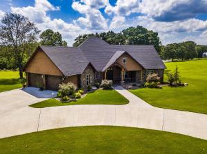 Very quality built custom home, all solid wood doors and trim, cabintry and fixtures all top line, owner is horse person and is so decorated but lends itself to whatever style buyer likes. High ceilings throughout, open living, kitchen, dining area, leads to huge covered back porch that overlooks pond, room to have building site on either side of house and could be sold for $485,000 with those sites excluded.Arrangement is excellent with door from garage to back hall which opens to huge laundry area then to master bath and on into master bedroom which has another door to hallway and great view of pond; hallway leads to front entry and has powder room at one side. Front entry is wide and has entrance to office with ''barn'' doors--most quality doors available MUST SEE