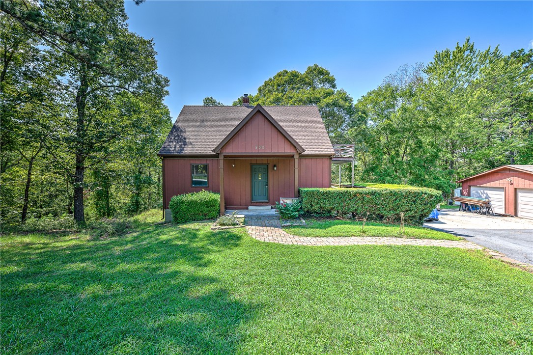 At this stunning recently remodeled Beaver Lake Area home, you can enjoy country living within city limits. This dynamic property features 2.66-acres, a detached 2-car garage/workshop, and a partial wrap-around deck! Brand new expanded kitchen with custom white oak cabinets and open shelving, and white quartz countertops- truly a show-stopper! Fully finished walk-out basement with second bathroom, living room, and bedroom. Detached garage is mostly finished and insulated with new windows. You will be surrounded by tall, beautiful trees, be close to the lake, and close to shopping and restaurants, but secluded enough to feel like you're nestled in the woods! 5-10 mins from two marinas, and a 5 minutes drive to Hobbs State Park for biking, hiking or camping, 15 minutes to DT Rogers and 30 minutes to Bentonville. Don't pass up this private haven!
