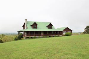 **HOME with a VIEW** set in the Ozark Mountains between Branson, MO and Harrison, AR. Custom built, wrap around porch, and on a paved road. 38 X 40 insulated metal shop building with RV door. Main level master with additional 2 bedrooms up and 1 bedroom in basement. Come see this Ozark oasis.