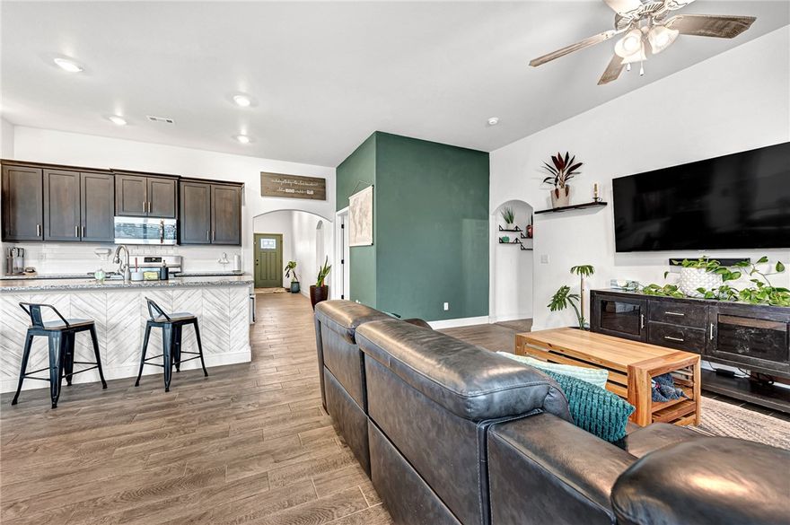 Your next chapter starts here. Step inside this move-in-ready home with unique touches that invite relaxation. A vibrant forest green front door opens to a wide, bright hallway. The open living space welcomes natural light across wood-look tile, warm cabinets, and quartz counters. A calming green accent wall wraps the dedicated home office. The split floor plan offers privacy in the primary suite with a tile shower, double vanities, and two walk-in closets. Two spacious bedrooms and a full bath sit at the front of the home. A drop zone by the garage and a nearby laundry room help keep things tidy. Located in the newly completed Prairie Brook neighborhood—known for its friendly vibe and strollable sidewalks—this home is ready to welcome you.