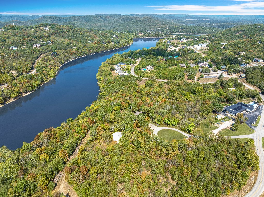 Claim one of the last waterfront homesites in Holiday Island with this 0.48-acre lakeview lot overlooking Table Rock Lake. The parcel is mostly level near the paved road and then gently slopes toward the water, giving you an ideal foundation for a custom home, wrap-around deck, or garden that takes full advantage of the spectacular views. Mature trees offer privacy and a serene, natural backdrop while still leaving plenty of open space for your design. Resort-style amenities, including a marina, fishing dock, two golf courses, a recreation center, swimming pool, park, and tennis courts, are just minutes away, and water, sewer, and electricity are already available onsite to simplify construction. Situated in Carroll County, this rare lakeside lot blends tranquility with convenience. We'll close with a local title company.