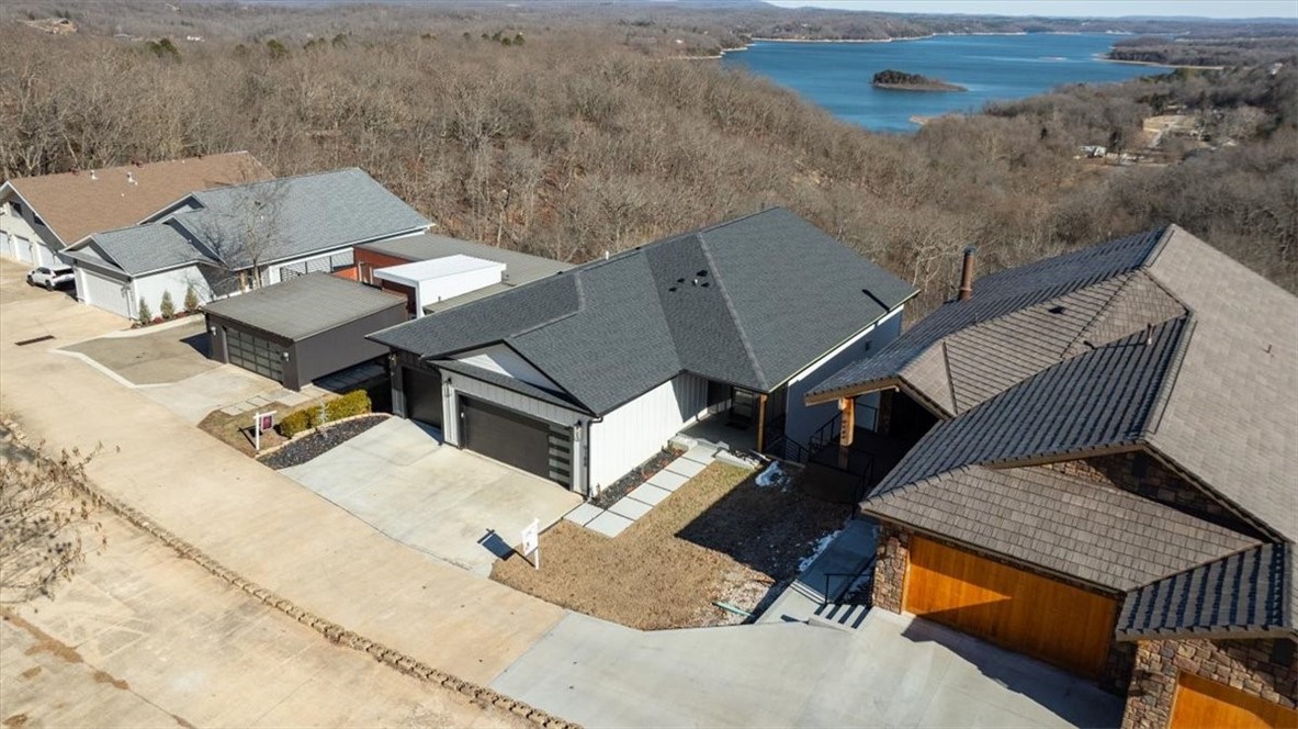 Prairie Creek Marina is just a golf cart ride away. This custom-built home offers stunning lake views across three levels and is packed with high end luxury finishes. It includes 5 bedrooms and 4.5 bathrooms, allows with a bunk room, three living rooms, making it ideal for families or large gatherings. Furniture can convey with acceptable offer.
The upper level features a gourmet kitchen equipped with GE Cafe appliances, perfect for cooking and entertaining. The middle floor boast a custom bar, enhancing the entertainment options. The third level can be closed off for privacy, making it perfect for an owners retreat while Airbnb the top 2 levels or use it as a mother-in-law suite. This level includes a full kitchen, full laundry and incredible views.
No expense was spared in the design of this home. The custom bunk beds features trim that matches the decor in bedrooms creating a cohesive look. Additionally, each bunk is equipped with night light for reading and convenient outlets for charging devices.