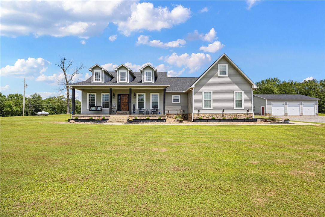 Tucked away on nearly 10 private acres, this modern farmhouse offers a rare blend of open space, thoughtful design, and everyday function. From the moment you arrive, you’ll feel the peace that only land can provide—room to breathe, grow, and live fully. A detached 3-car shop stands ready for your projects, equipment, or hobbies. Spacious, versatile, and well-equipped, it’s more than just a place to park — it’s a place to build. The home offers over 2,300 square feet with three bedrooms, two and a half baths, and a flexible bonus room that can easily serve as a fourth bedroom or office. The open-concept floor plan is anchored by a striking floor-to-ceiling rock fireplace and trimmed with curated finishes throughout. Step outside to a large, extended back deck overlooking your private corner of Arkansas countryside. Complete with a built-in safe room, whole-house generator, and modern farmhouse charm, this property is more than a home. It’s a lifestyle rooted in freedom, space, and intention.