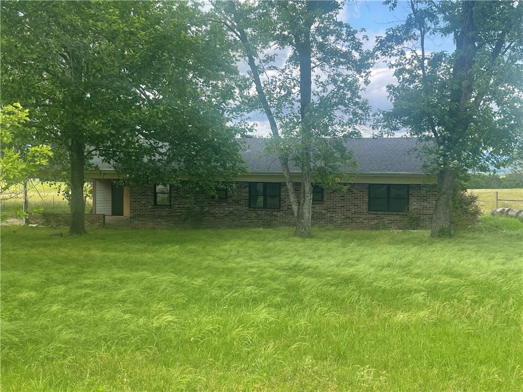 SWEET COUNTRY LIVING with A SURREAL VIEW & QUIET SETTING. This brick beauty and its detached shop/garage offer a rural, peaceful haven. The mountain view is unbelievable. Home boasts a NEW ROOF, additional sunroom. Roomy floor plan consists of: a kitchen, formal dining room, large family room with fireplace/insert, 3 bedrooms, and a sunroom/game room/4th bedroom. Closets everywhere. All electric dwelling is definitely spacious and priced realistically. The detached garage has rooms modified for possible offices, and there are stables attached to the exterior. Potential to be a small hobby farmette or just a blissful country oasis.