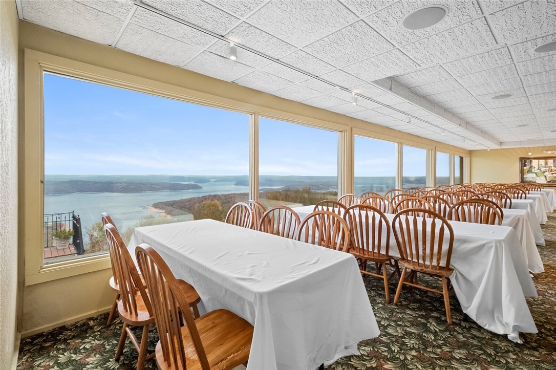 Stellar opportunity to operate a restaurant or event center with breathtaking views from the highest
point in Benton County, AR. At over 1,800' elevation, Whitney Mountain Lodge offers unparalleled
scenery and versatility. The property includes a commercial kitchen equipped with a vent hood, grills,
ovens, dishwasher, sinks, prep stations, and some accessories to run a restaurant. Your guests will be
greeted with a spacious reception area, which then flows into elegant dining/banquet rooms featuring
large windows showcasing panoramic lake views, and flow seamlessly into a spacious bar area. Two
large decks provide additional scenic seating outdoors with views of the lake. Don't miss this opportunity to run a high-end restaurant or event/wedding venue with the best views in Arkansas!