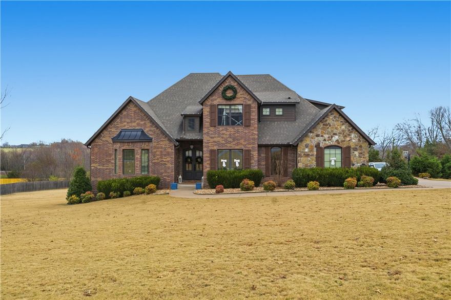 Charming home on 1.59 acres in picturesque Sassafras Wine Country! Perfectly positioned between Fayetteville and Springdale, this home offers an upscale yet relaxed lifestyle where country living meets everyday convenience. You are welcomed into the home with rich hardwood floors, lofty ceilings, and large, bright, open living spaces. The eat-in chef's kitchen features a large marble island & countertops, shiplap ceiling, two pantries, and plenty of room for gathering. Formal dining & living rooms, office, laundry, and primary suite are located on main level. Upstairs you'll find a second primary suite, second laundry, two additional bedrooms, and large bonus room, wired for sound w/ wet bar. Step outdoors onto your east-facing covered deck that overlooks an evergreen-lined patio and park-like backyard. Enjoy peaceful surroundings and good neighbors just minutes from the hustle and bustle of town!